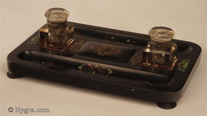 Papier mch inkstand impressed to the base "JENNENS & BETTRIDGE BIRMm"  beneath a Crown decorated in green red blue and gilt decoration, standing on turned feet. It has two period faceted glass inkwells with hinged tops. Enlarge Picture